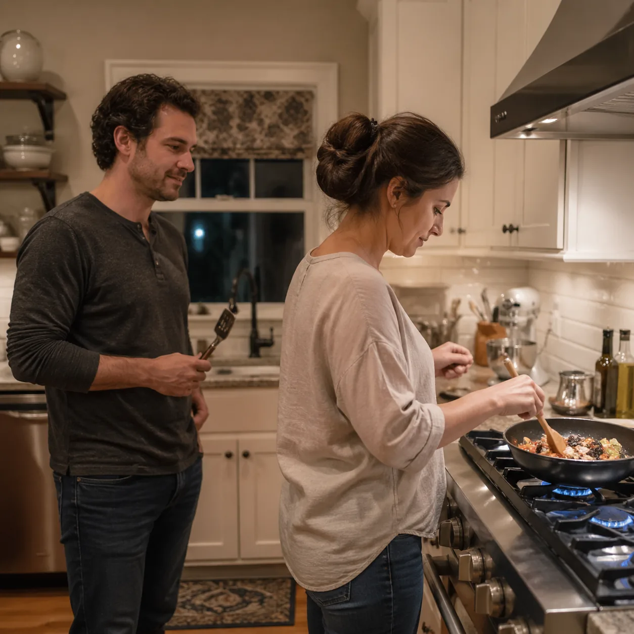 Realistic lifestyle photo of a husband standing in a kitchen holding a single utensil while his wife actually cooks dinn
