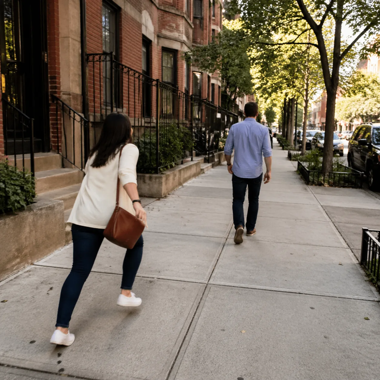 Funny realistic lifestyle photo of a husband walking three steps ahead of his wife on a sidewalk while she power-walks t